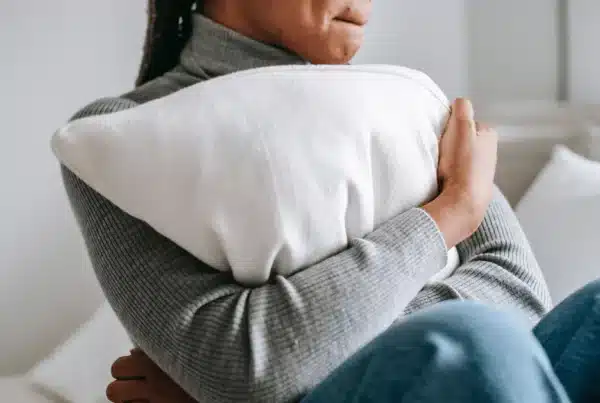 Woman hugging pillow seeking inpatient mental health treatment