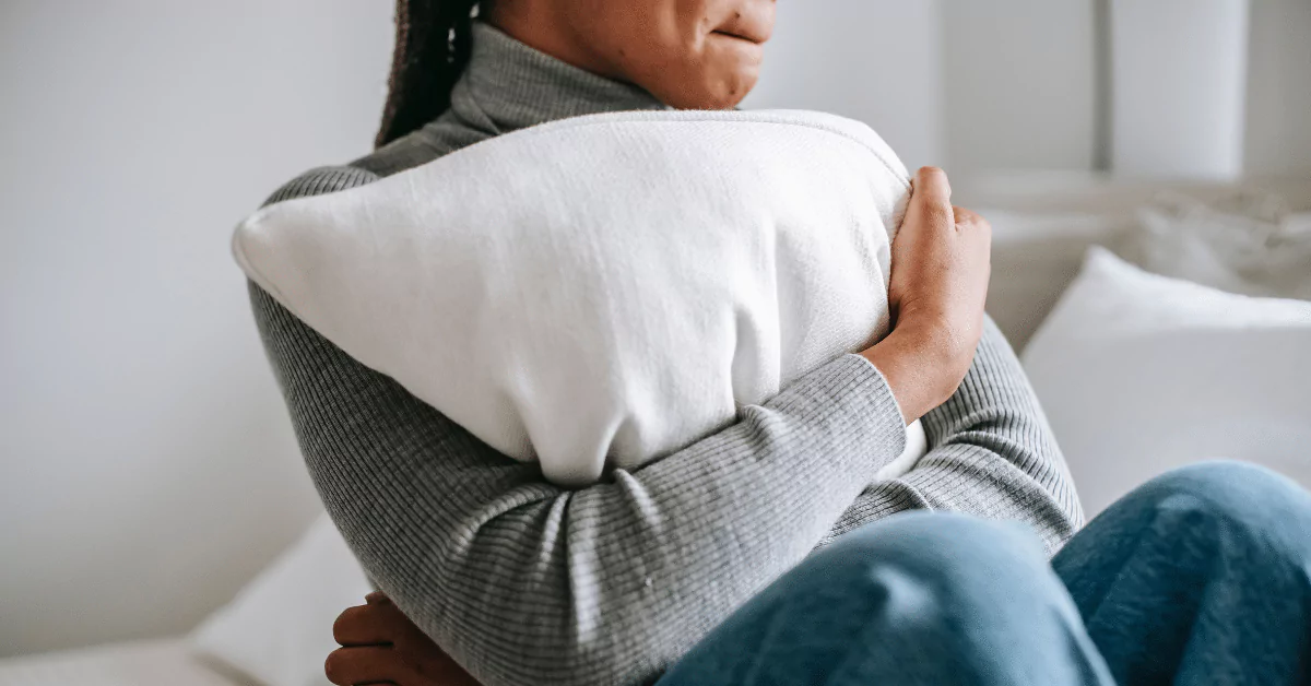 Woman hugging pillow seeking inpatient mental health treatment